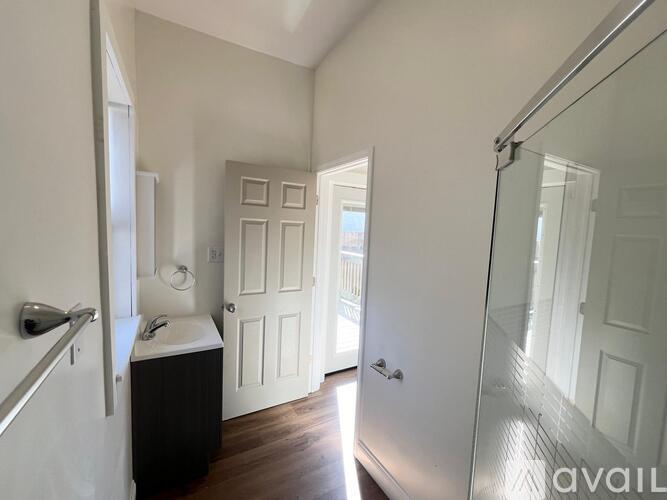 A bathroom with a white door and a glass shower door.