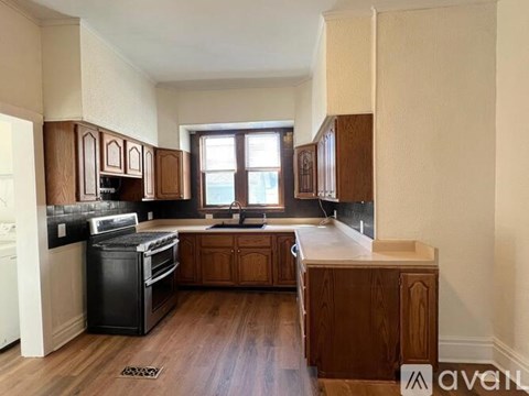 A kitchen with wooden cabinets and a black stove top oven.