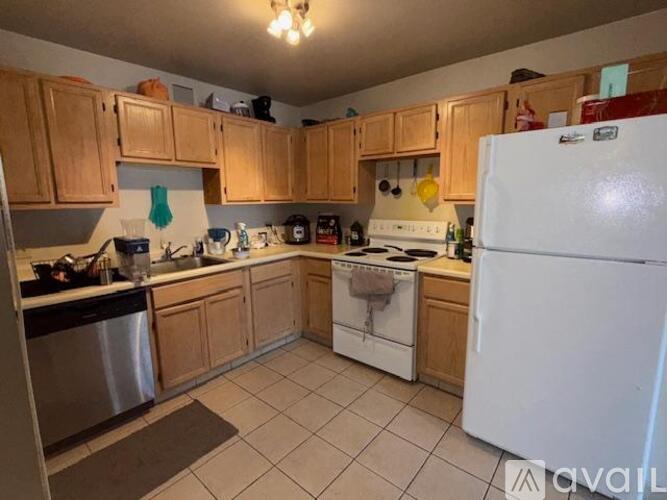 A kitchen with wooden cabinets and a white refrigerator.