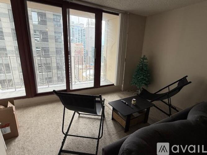 A living room with a black chair and a small table with a candle on it.