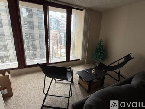 A living room with a black chair and a small table with a candle on it.