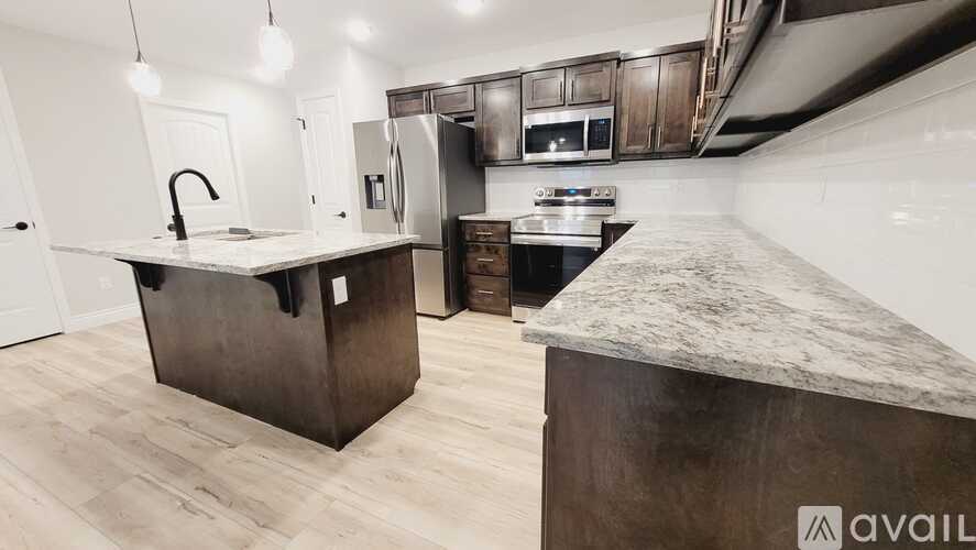 A kitchen with a marble countertop and wooden cabinets.