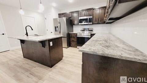 A kitchen with a marble countertop and wooden cabinets.