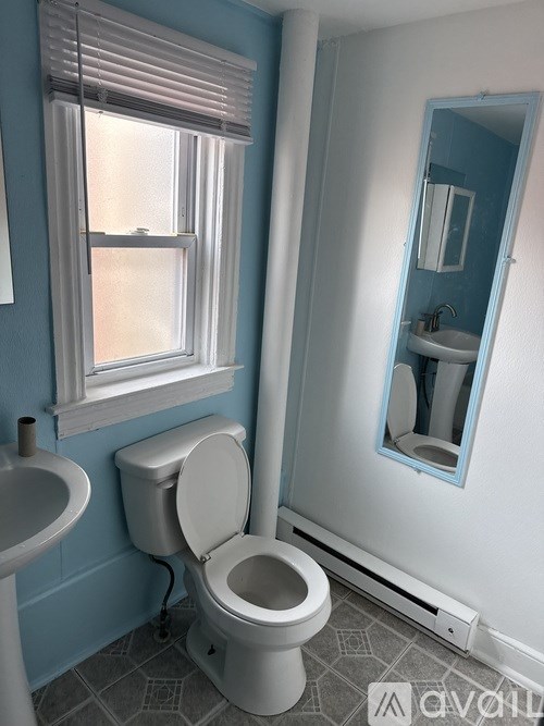 A white toilet in a bathroom with blue walls.