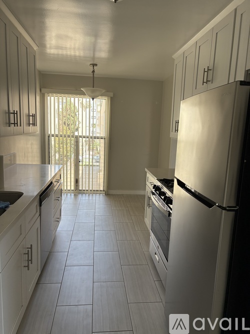 A kitchen with white cabinets and a white refrigerator.