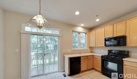 A kitchen with black appliances and wooden cabinets.