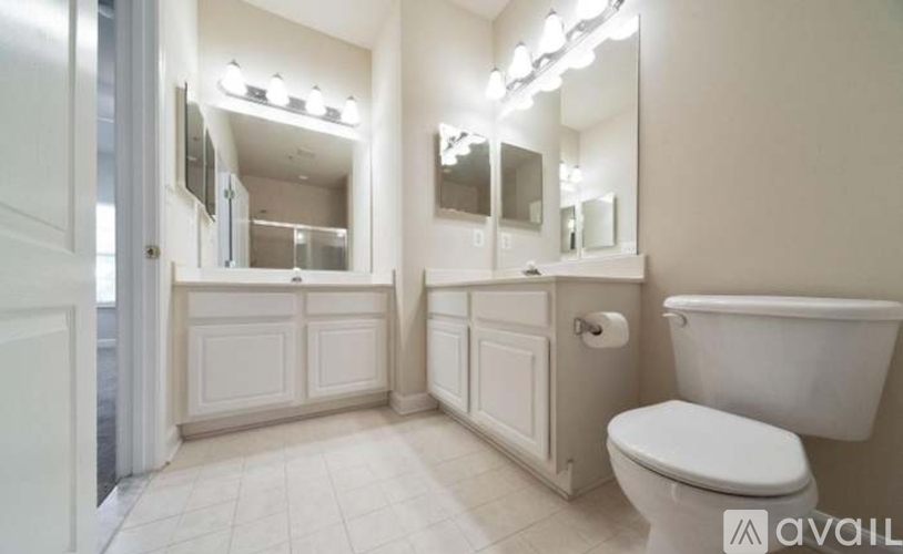 A white toilet sits next to a white bathtub in a bathroom.