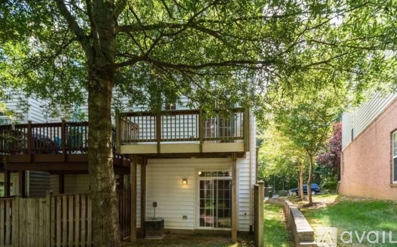 A house with a balcony and a tree in front of it.