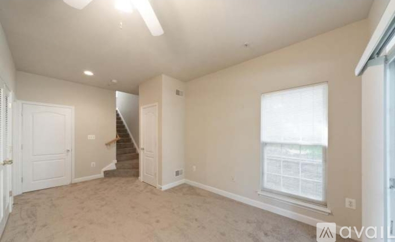 A spacious room with a staircase leading to the second floor.