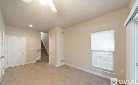 A spacious room with a staircase leading to the second floor.