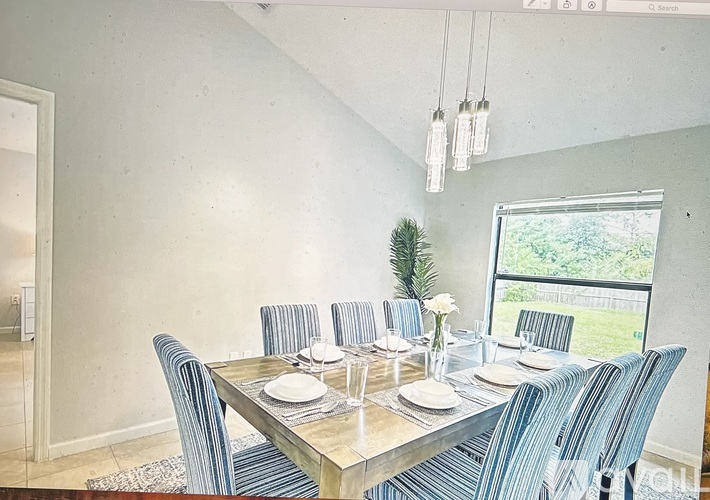 A dining room with a table set for six.