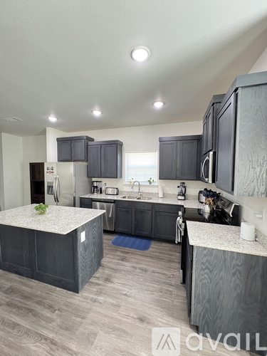 A modern kitchen with dark wood cabinets and a central island.