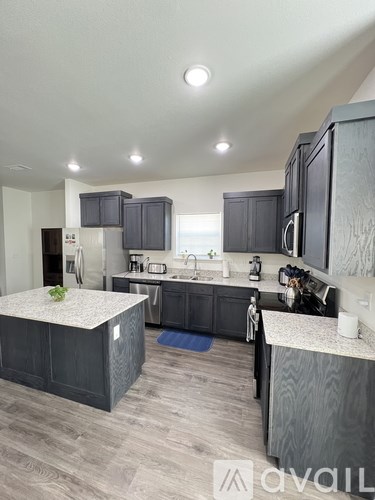 A modern kitchen with dark wood cabinets and a central island.