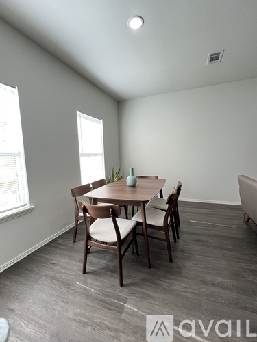 A dining room with a table and chairs.