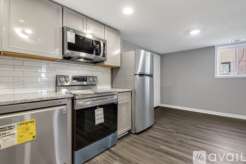 A kitchen with a stainless steel oven and refrigerator, and a microwave above the stove.