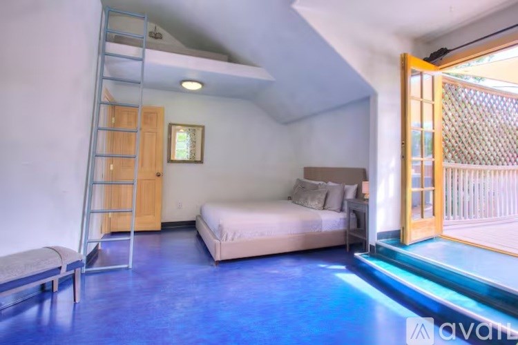 A bedroom with a bed, a bench, and a ladder.