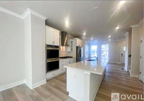 A spacious kitchen with white cabinets and a large island.