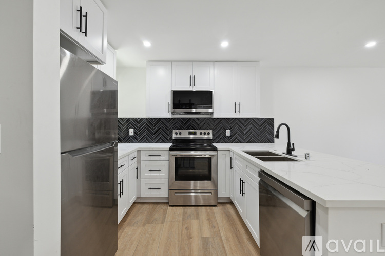 A modern kitchen with stainless steel appliances and white cabinets.