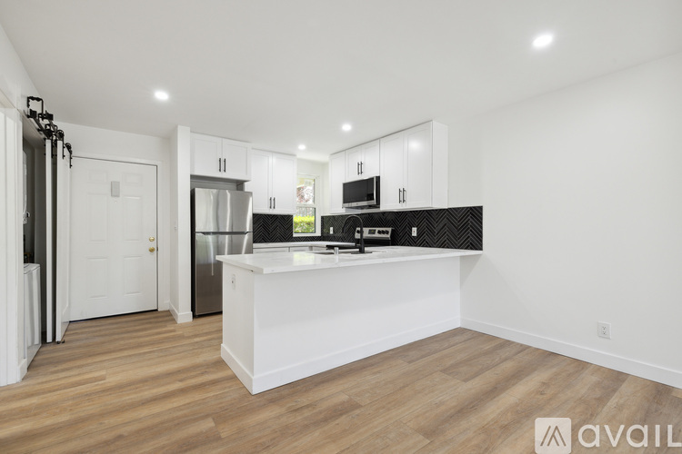 A kitchen with a refrigerator, oven, and sink.
