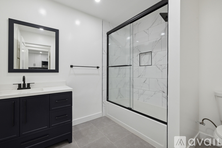 A kitchen with a white counter top and a white fridge with a black handle.