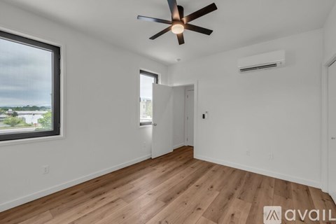 A room with a ceiling fan and wooden flooring.