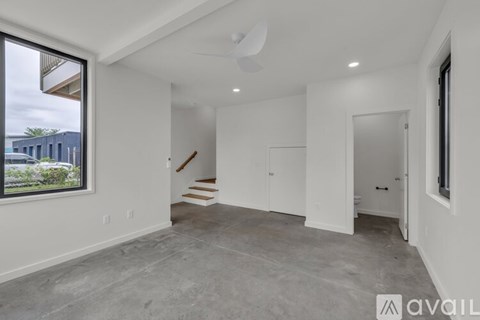 A spacious, empty room with a staircase leading to another level.