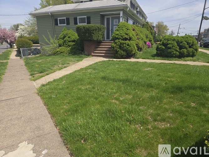 A house with a green lawn and a sidewalk in front.