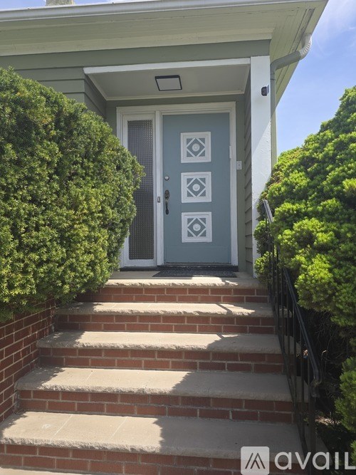 A house with a blue door and steps leading up to it.