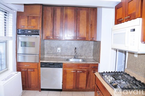 A kitchen with wooden cabinets and a white oven.