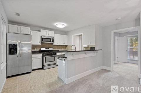 A kitchen with white cabinets and stainless steel appliances.