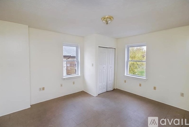 Empty room with two windows and a door.