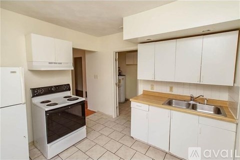 A kitchen with white cabinets and a black stove top oven.