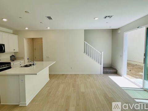 A kitchen with white cabinets and a wooden floor.