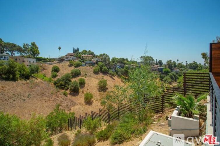 A hillside with a fence and some buildings.