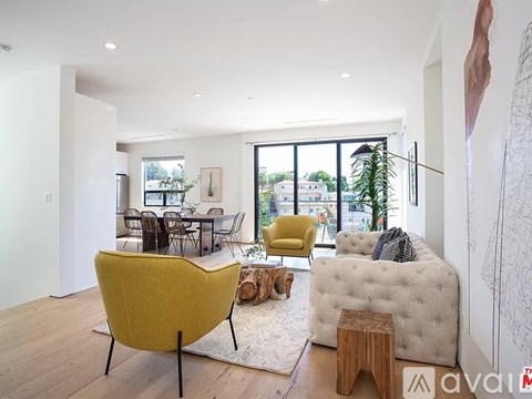 A living room with a yellow chair and a white couch.