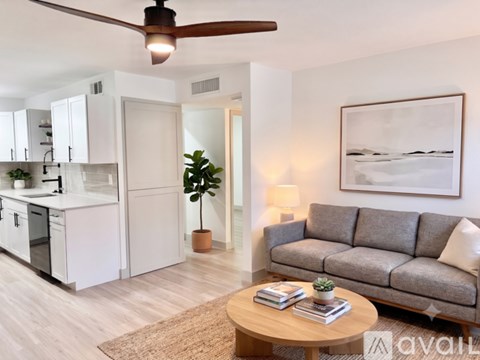 A modern kitchen with white cabinets and a stainless steel refrigerator.