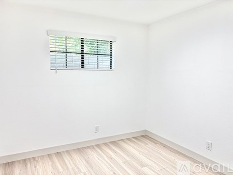 A room with a window covered in blinds.