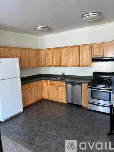 A kitchen with wooden cabinets and black appliances.
