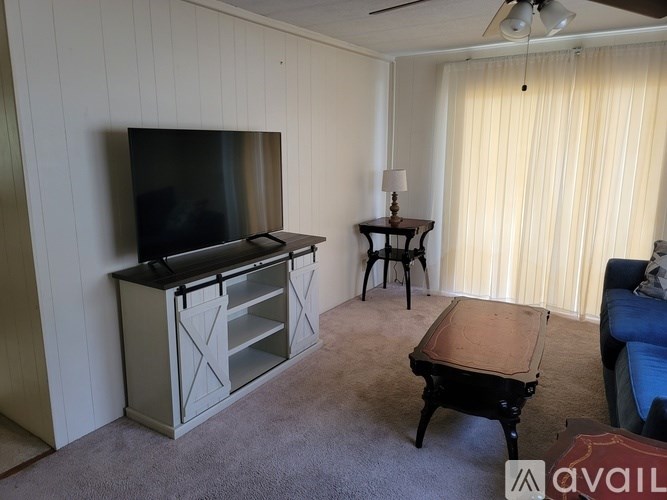 A living room with a television, a table, and a couch.