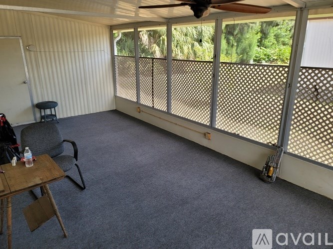 A patio with a table and chairs and a ceiling fan.