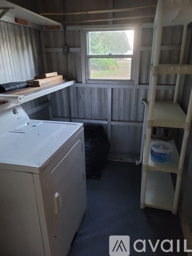 A small room with a cabinet, a window, and a ladder.