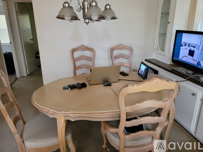 A table with chairs and a television in a room.