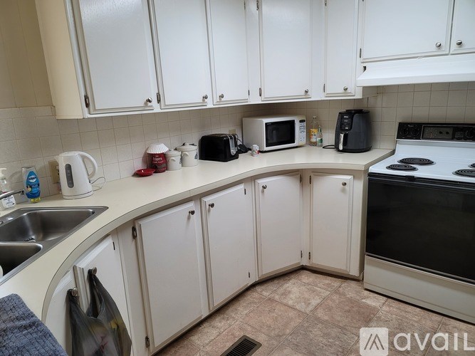 A kitchen with white cabinets and appliances.