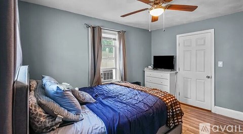 A bedroom with a bed, dresser, and window.