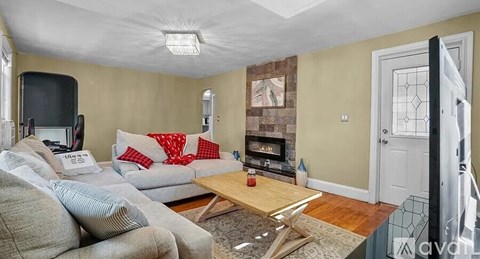 A living room with a grey couch, a coffee table, and a fireplace.