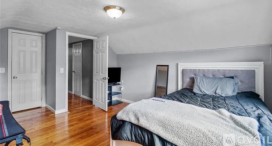A bedroom with a bed, chair, and wardrobe.
