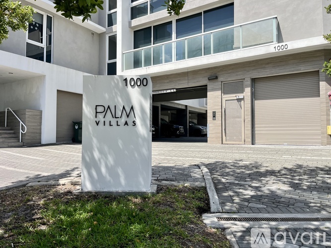 A sign for Palm Villas stands in front of a building.