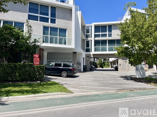 A modern building with a parking lot in front.