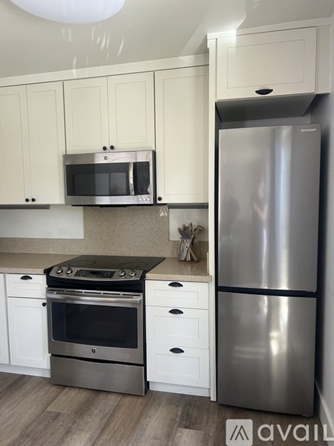 A modern kitchen with a stainless steel refrigerator, oven, and microwave.