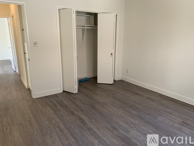 A room with a white door and a grey floor.